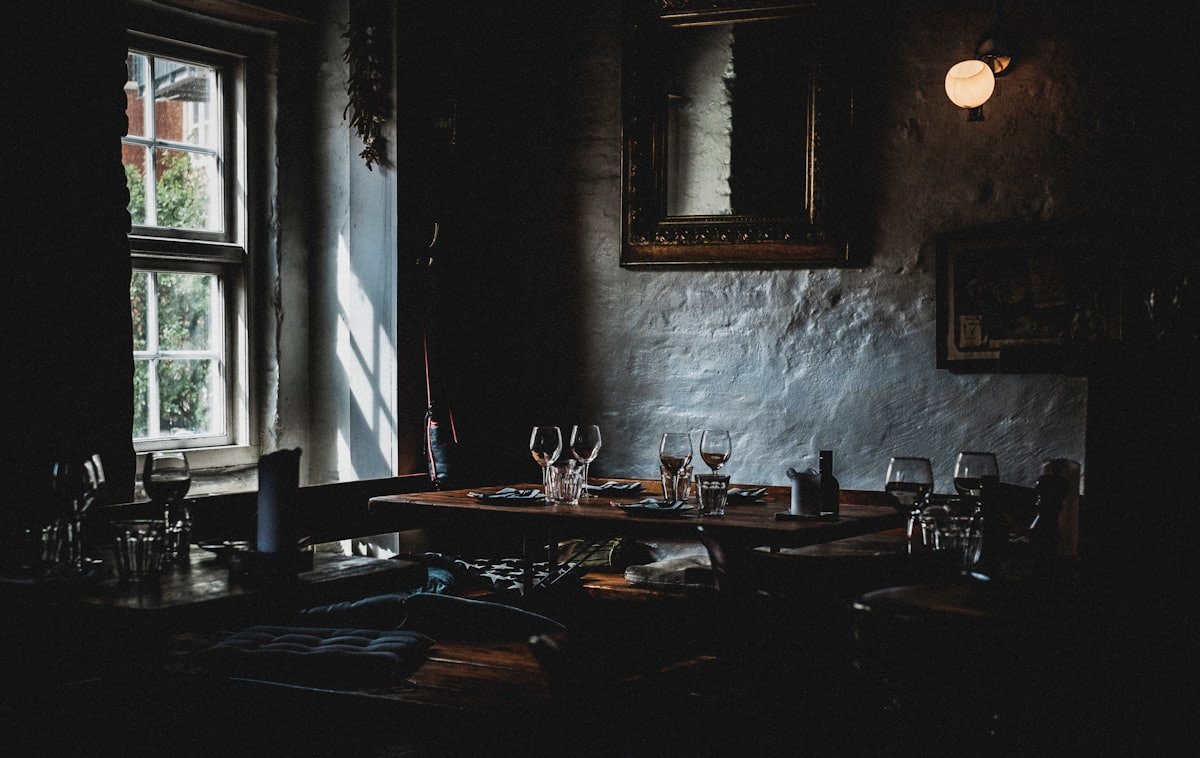 Salle à manger de Maison Aurèle, éclairage tamisé et boiseries sombres